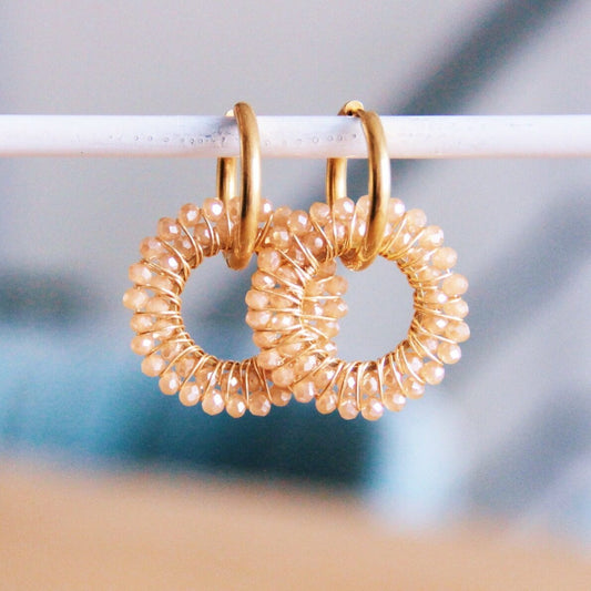 Gouden oorbellen met ronde facet hanger - beige